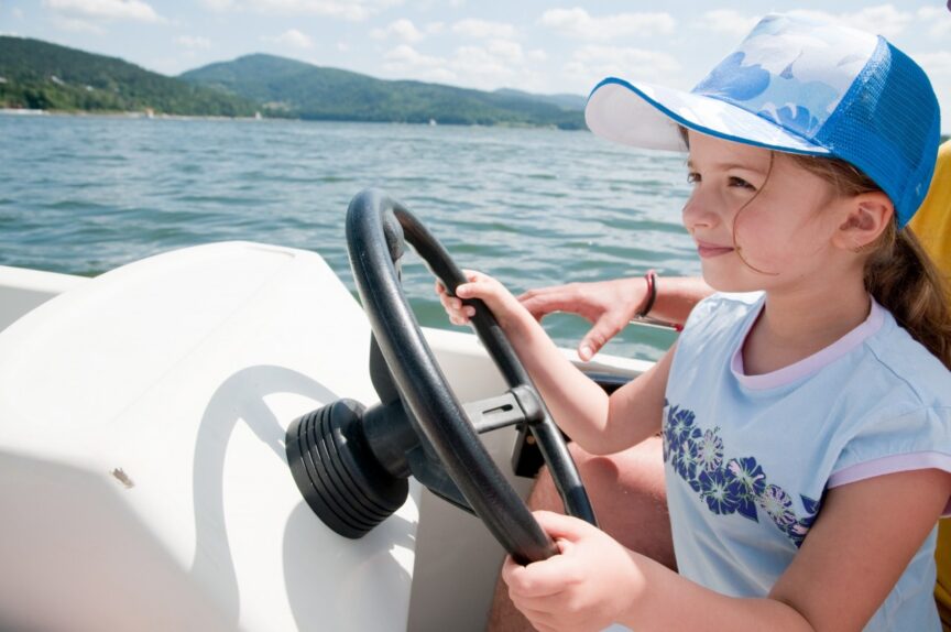 Little girl driving motorboat Lake Winnipesaukee attractions
